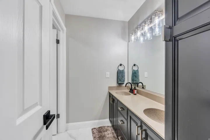 Dual vanity with integrated sinks, light-toned countertop, and dark cabinetry