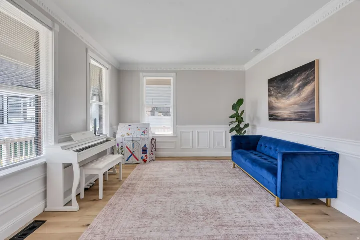 Hardwood-finish flooring with crisp white crown molding and wainscoting