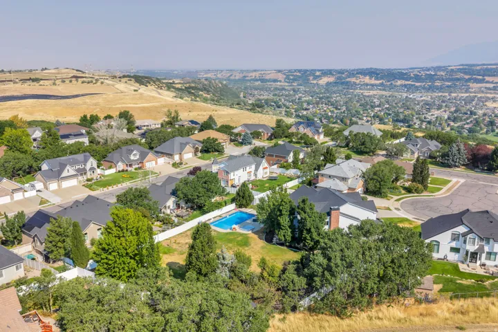 Residential neighborhood with varied architectural styles, mature landscaping, paved streets, and a swimming pool