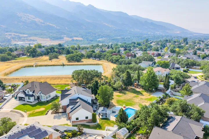 Expansive residential property featuring a swimming pool, mature trees, and a mountain backdrop