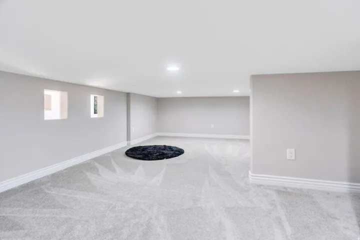 Expansive interior with light gray walls, light gray carpeting, recessed ceiling lighting, and crisp white trim