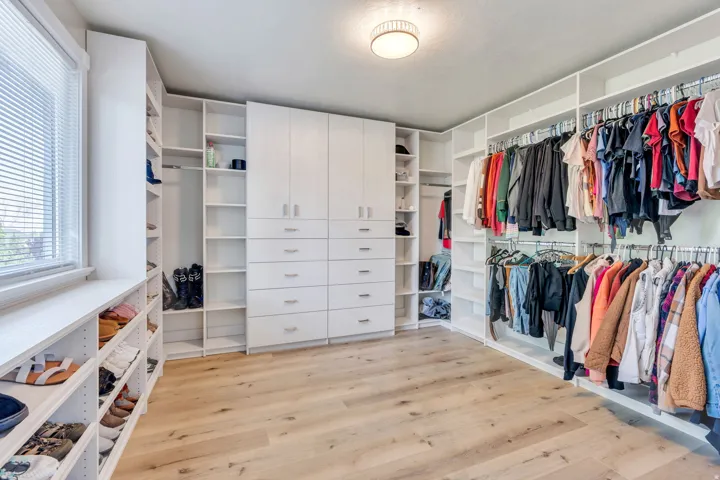 Custom built-in closet system featuring multiple hanging rods, shelving units, and drawer storage