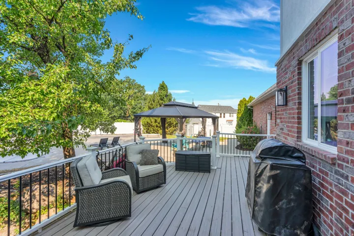Expansive exterior deck with composite flooring, black metal railings, and a gazebo feature