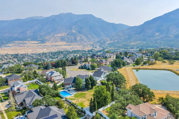 Residential neighborhood featuring diverse architectural styles, mountainous backdrop, and a private swimming pool