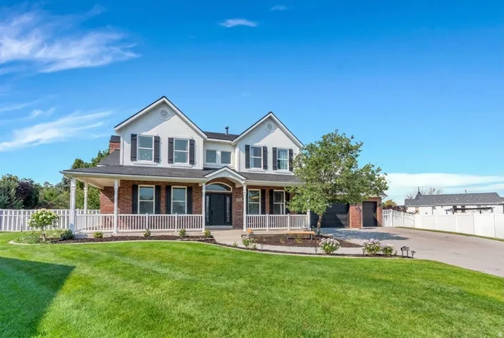 Brick and siding exterior with a covered porch, white railing, and dark shutters