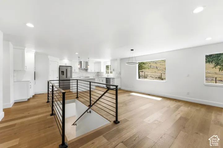 Open concept living area with wood-finish flooring, white walls, and recessed lighting