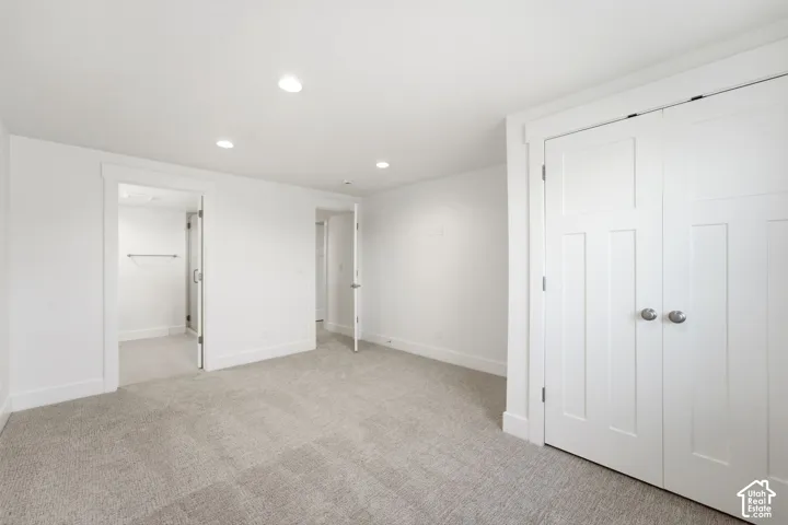 Recessed ceiling lighting, light gray carpeting, white trim, and white panel doors with brushed nickel hardware