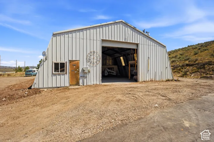 Corrugated metal structure with a large open bay, side entry door, and a single window