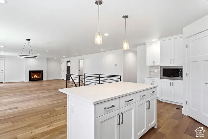Central island with a light-toned countertop, white shaker cabinetry, and dark hardware