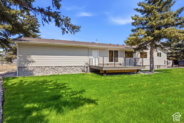 Rear elevation with light-toned siding and stone-finish foundation