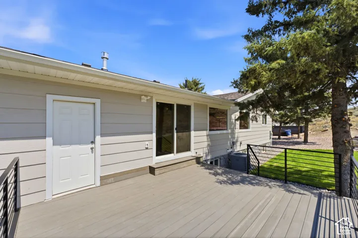 Expansive deck with composite decking, white siding, and black metal railings
