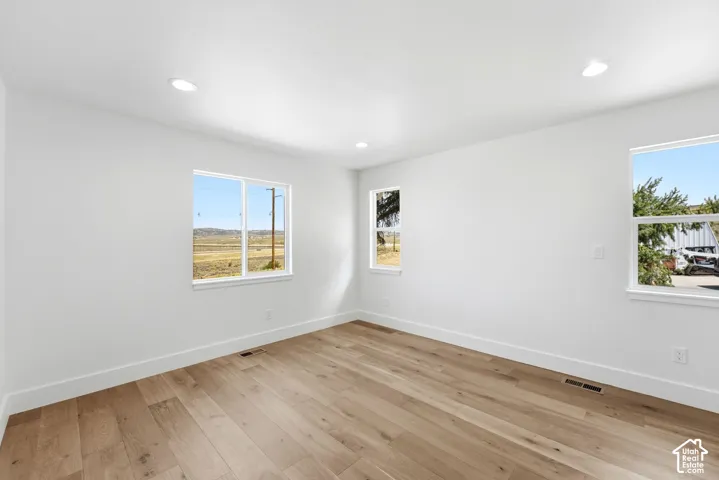 Recessed lighting, wood-finish flooring, white walls, and multiple windows