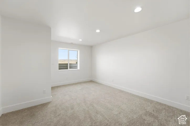 Neutral color palette throughout, recessed ceiling lighting, light-toned carpet, and a large window