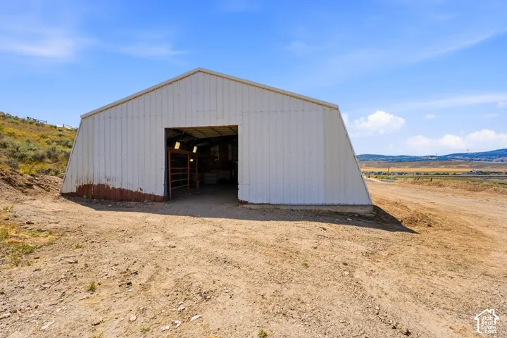 Metal-sided building with a large entry, a gravel floor, and a metal gate