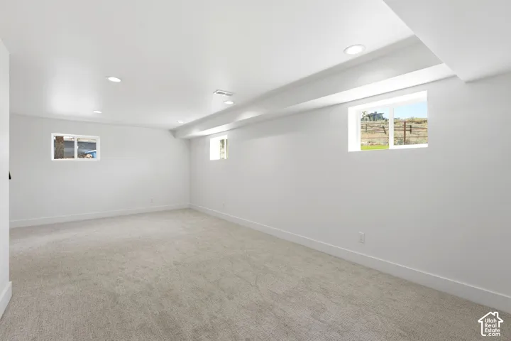 Recessed lighting, light-toned carpeting, white walls, and multiple windows