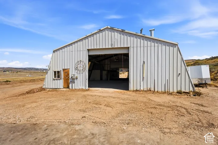 Metal-sided structure with a gabled roof and large open bay entrance