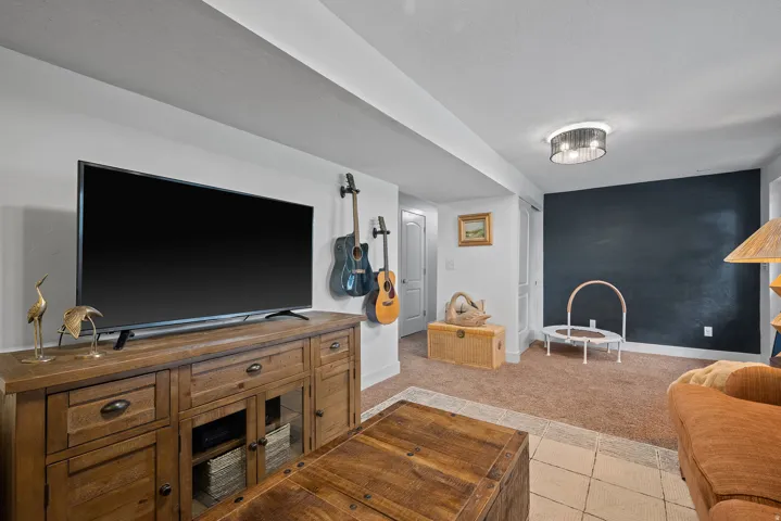 Carpeted flooring, recessed lighting, and a dark accent wall