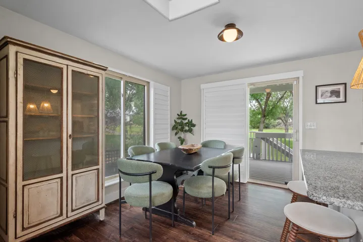 Hardwood-finish flooring, sliding glass door with white louvered blinds, and granite countertop