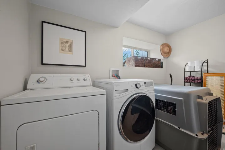 Laundry area with a window and light-toned walls