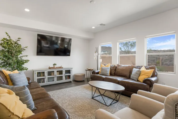 Spacious room featuring wood-finish flooring, recessed lighting, and multiple windows