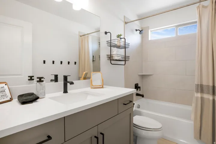 Integrated vanity with an undermount sink, a white countertop, and dark-finish fixtures