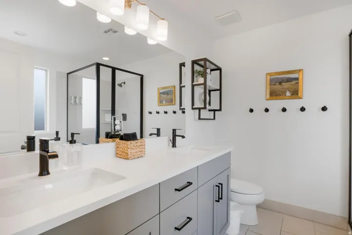 Dual vanity with integrated sinks, matte black hardware, and gray cabinetry