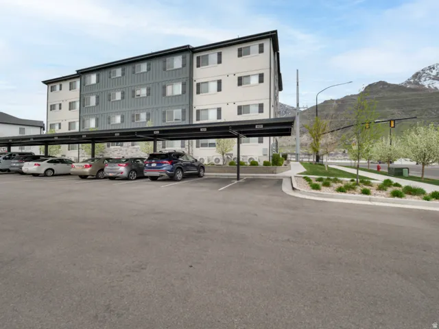 Multi-level building with covered parking structure, paved lot, and landscaped median