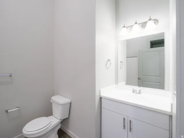 White vanity with an integrated sink, brushed nickel faucet, mirror, and a three-light vanity fixture