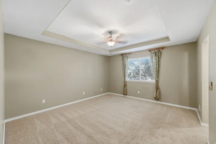 Tray ceiling featuring a ceiling fan