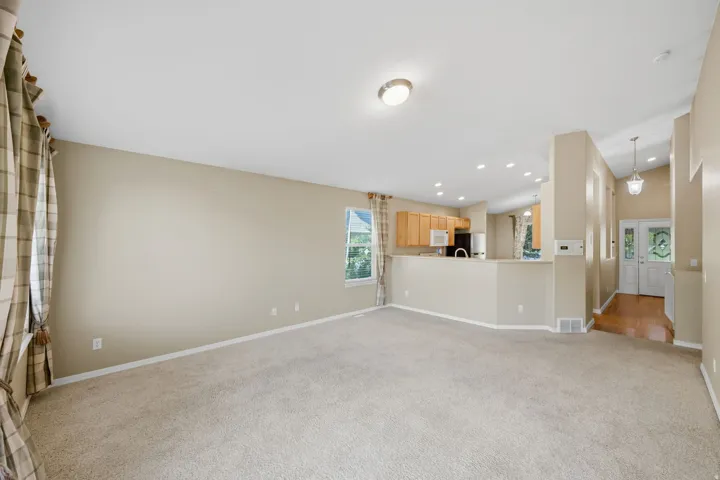 Recessed lighting, wood-finish cabinetry, stainless steel appliances, vaulted ceilings, and wood-finish flooring