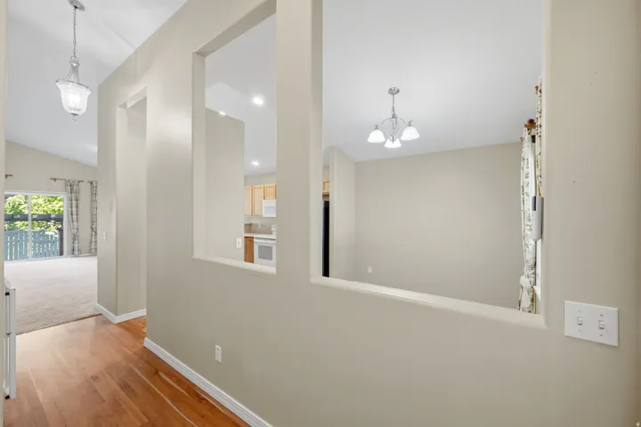 Wood-finish flooring, vaulted ceilings, pendant lighting, interior wall cutouts, and sliding glass doors