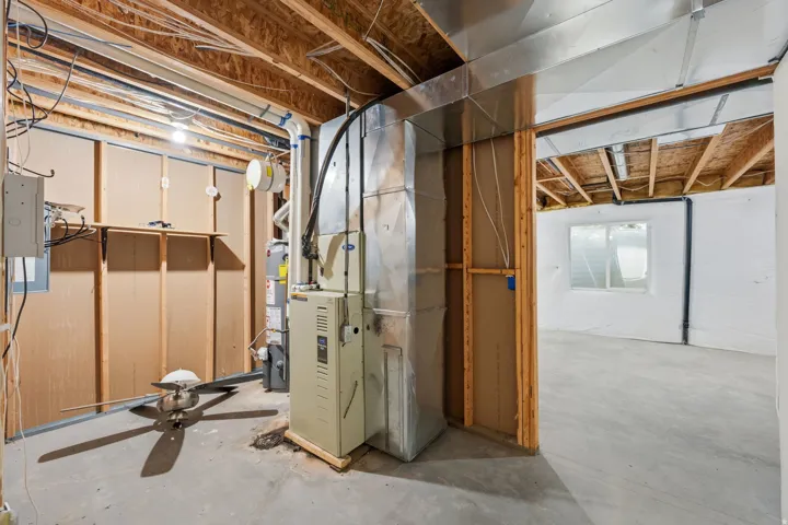 Concrete flooring, exposed ceiling joists, and a partial wall framing