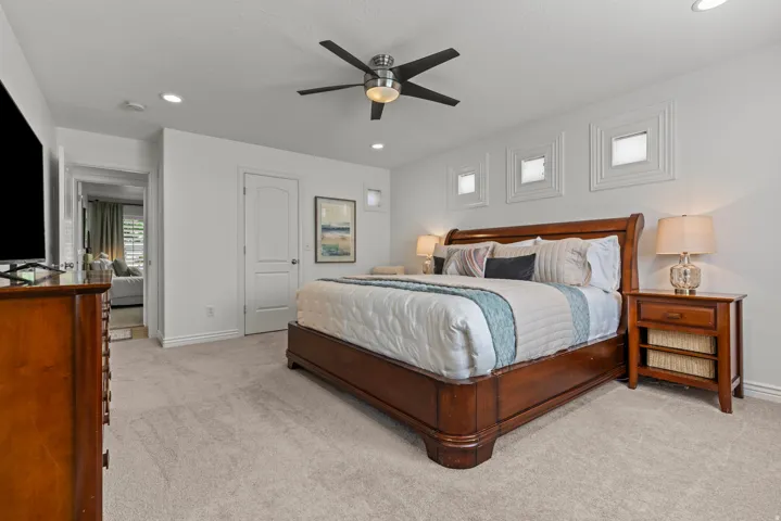 Carpeted bedroom featuring recessed lighting, a ceiling fan, and three transom windows