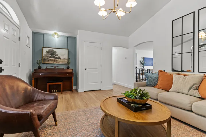 Bright and airy living room featuring hardwood-finish flooring, and abundant natural light from multiple windows