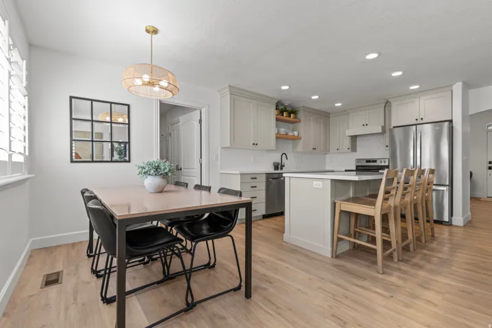 Open-concept dining and kitchen featuring wood-finish flooring throughout, and stainless steel appliances