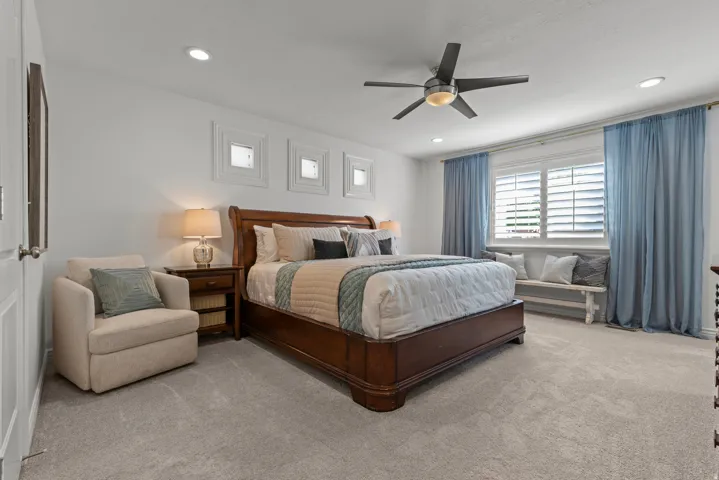 Spacious primary bedroom featuring neutral carpet flooring and natural lighting.
