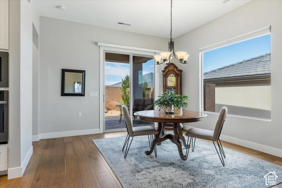 Hardwood-finish flooring, sliding glass door, recessed lighting, and a pendant light fixture