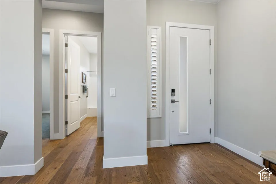 Wood-finish flooring throughout, bright white walls, and contemporary doors with integrated vertical lites