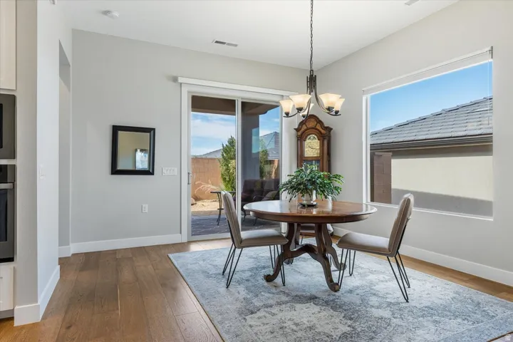 Hardwood-finish flooring, sliding glass door, recessed lighting, and a pendant light fixture