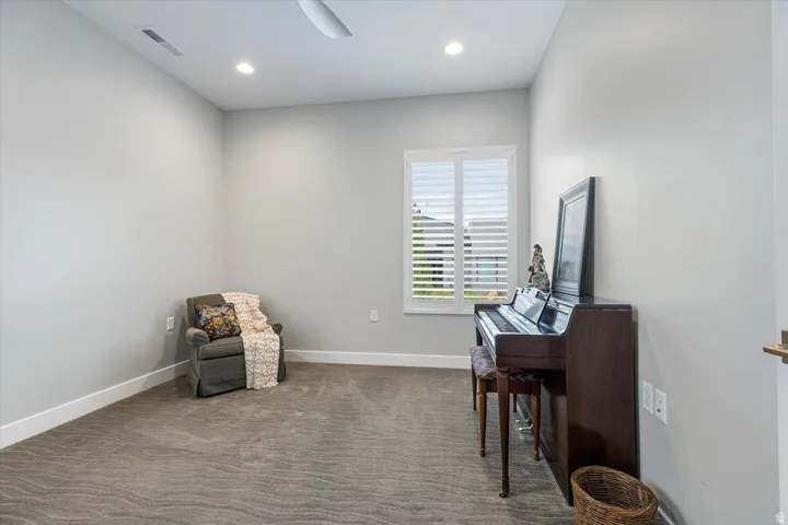 Recessed lighting, ceiling fan, white window shutters, and plush carpet flooring