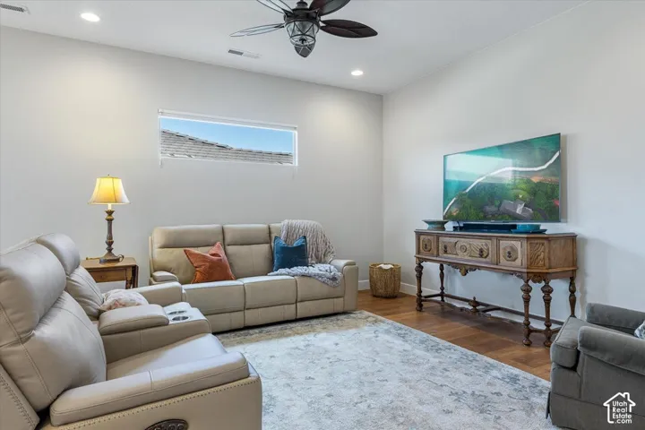 Recessed lighting, wood-finish flooring, a linear horizontal window, and a ceiling fan with integrated lighting