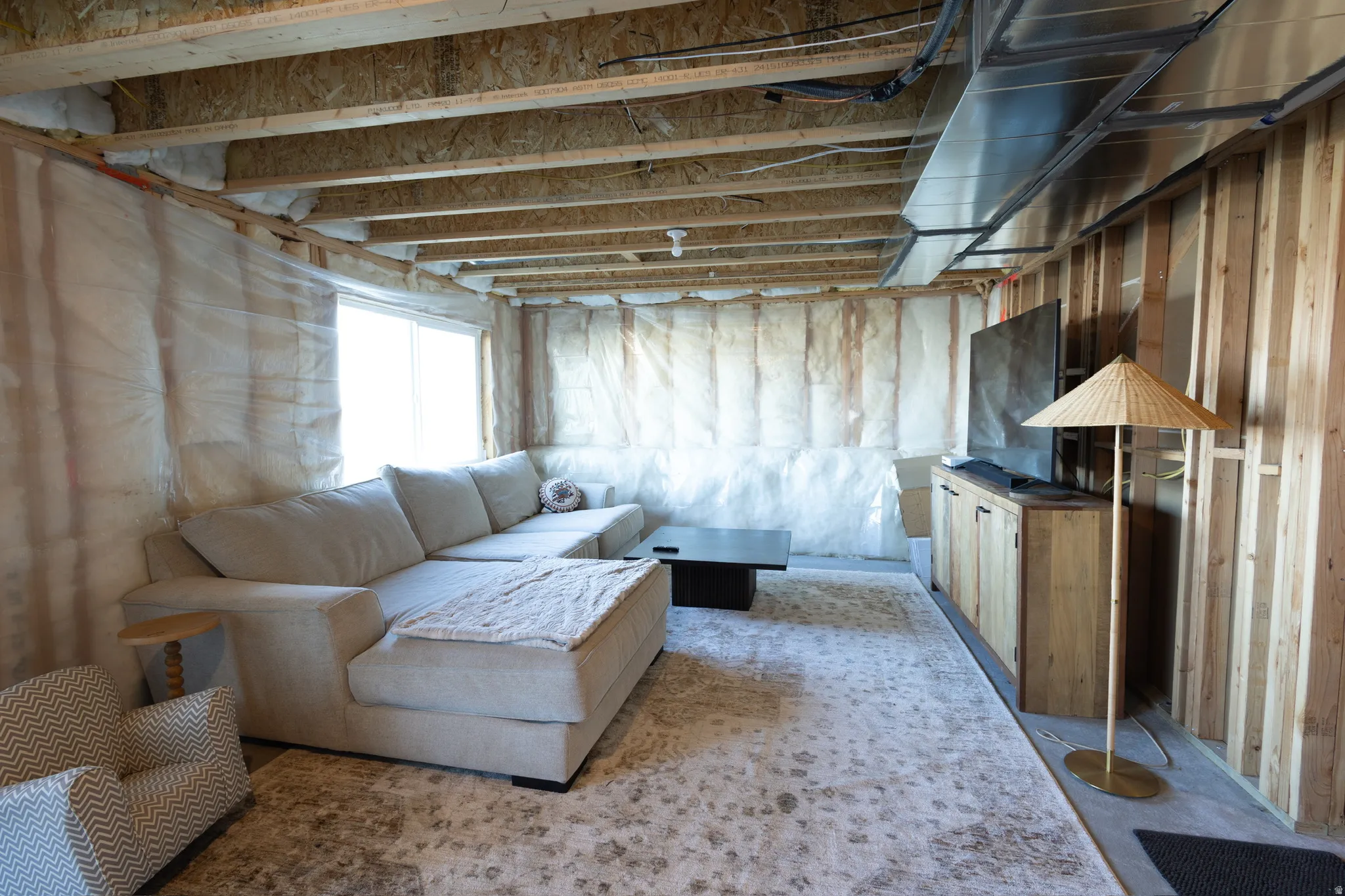 Exposed ceiling joists, framed walls, and an egress window