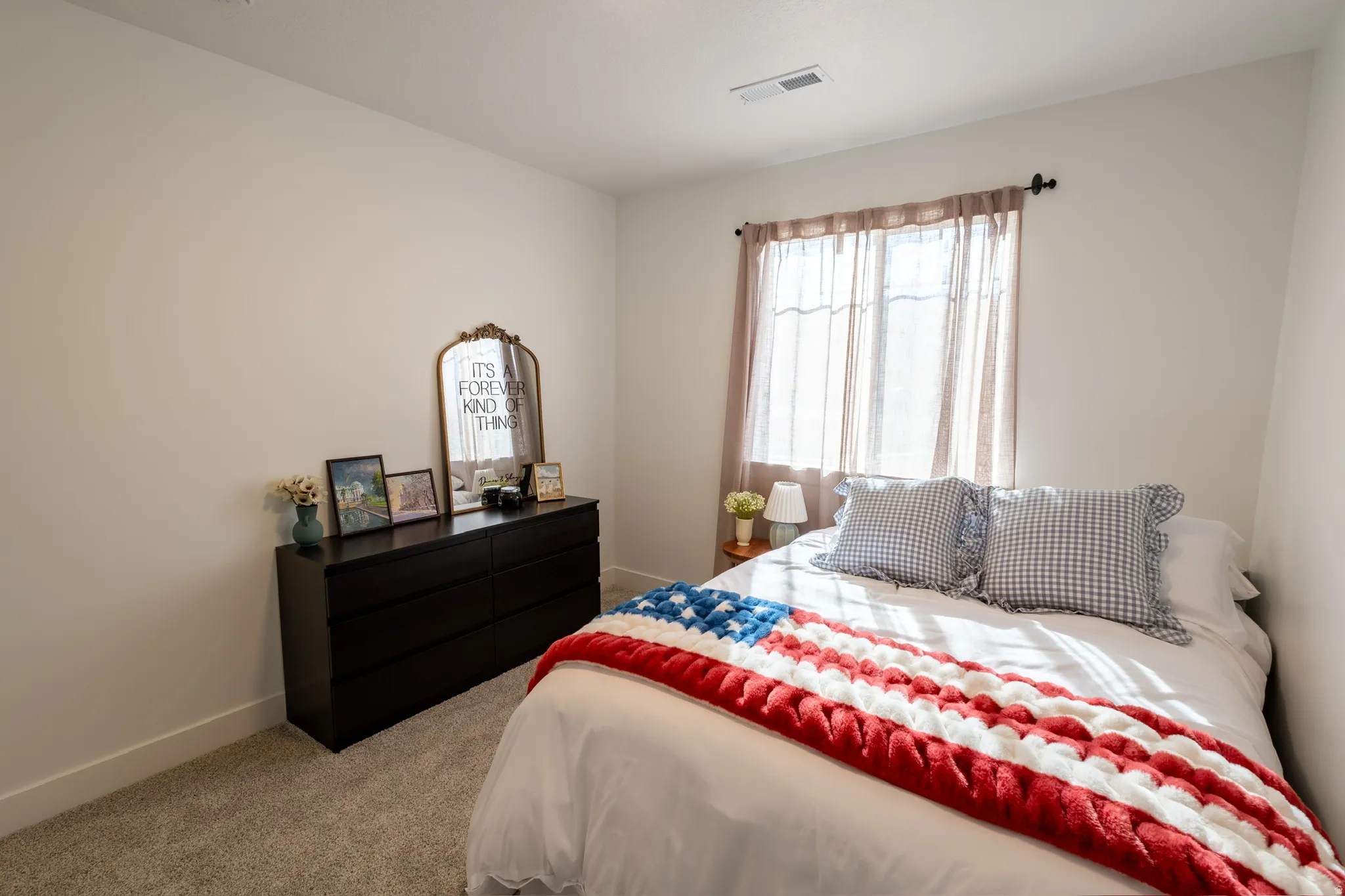 Window with sheer curtains, neutral wall paint, and carpeted flooring