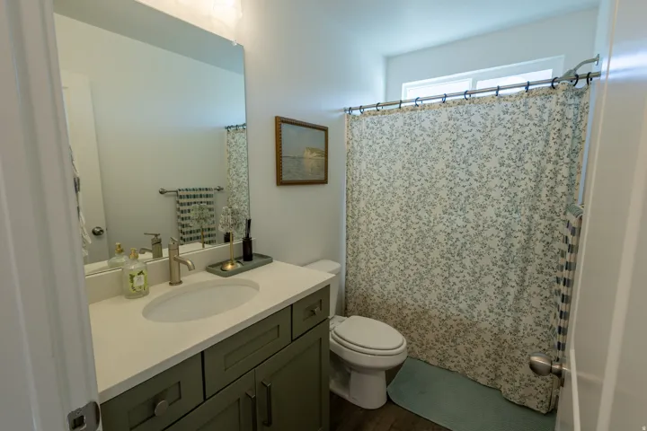 Vanity with a light-colored countertop, undermount sink, and brushed brass-finish faucet