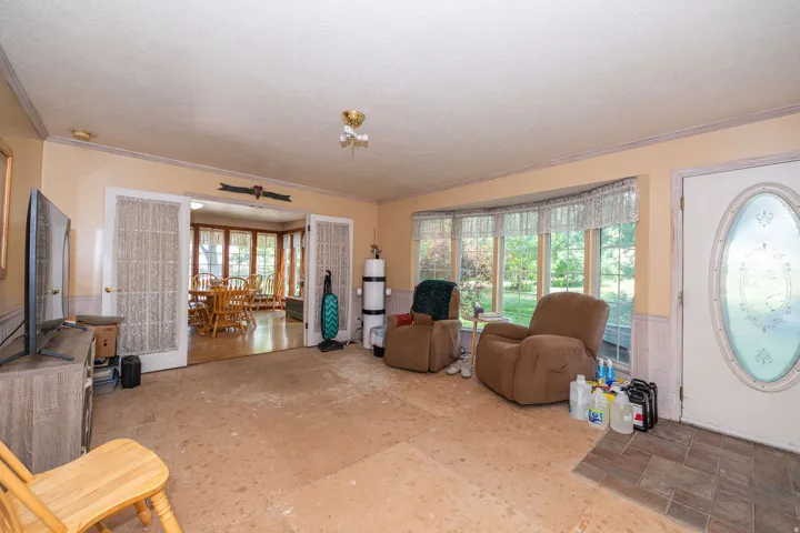 Bay window, decorative front door, crown molding, French doors, wood-finish flooring in adjoining room