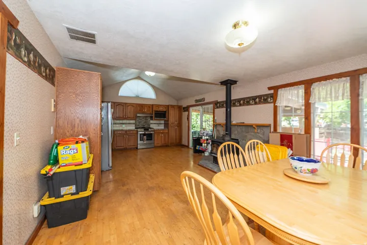 Wood-finish flooring throughout, vaulted ceiling, and an arched window