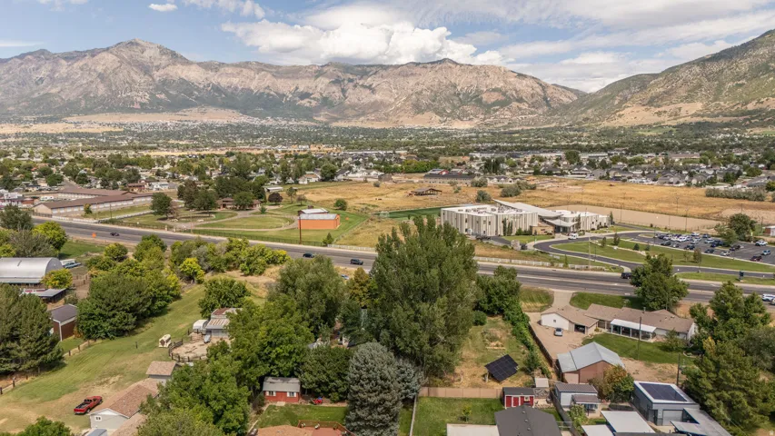 Expansive mountainous terrain with a residential community, green spaces, and a prominent roadway