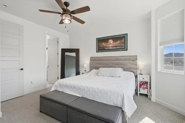 Room featuring light-colored carpeting, a ceiling fan with integrated lighting, and a window with mountain scenery
