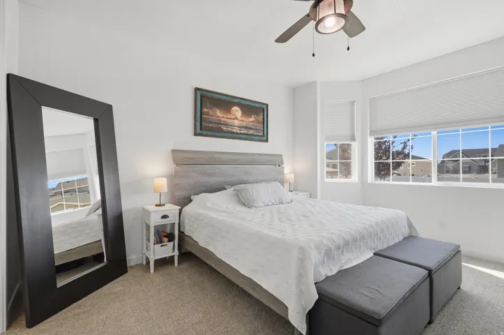 Recessed bay window with multiple windows, neutral tone carpet, and a ceiling fan with integrated lighting