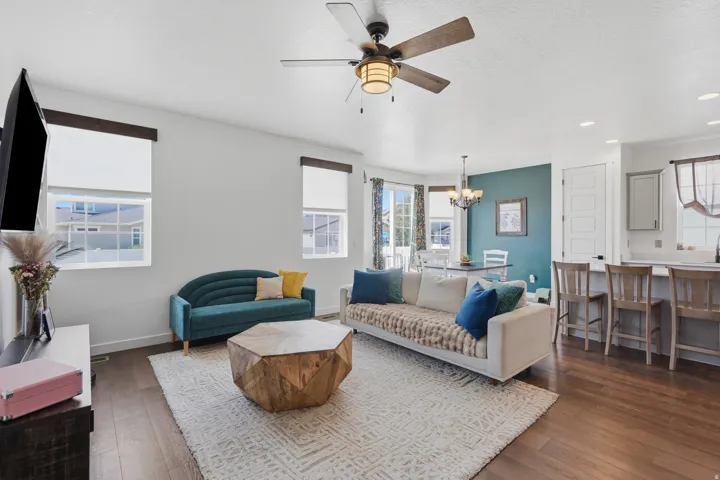 Open-concept living space featuring wood-finish flooring, recessed lighting, and a ceiling fan with integrated light